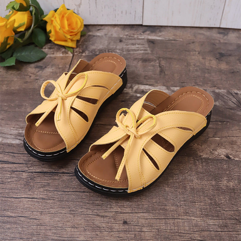 Chaussons à talons compensés plats avec nœud ajouré